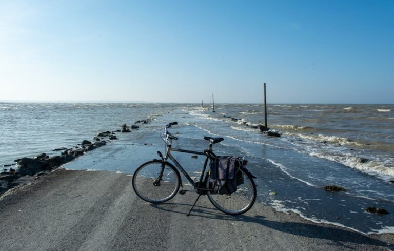 bike is parked next to flooded ocean road
