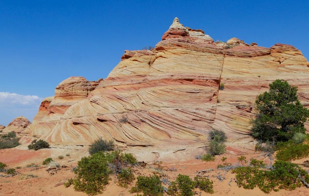 striped sedimentary rock formation against blue sky