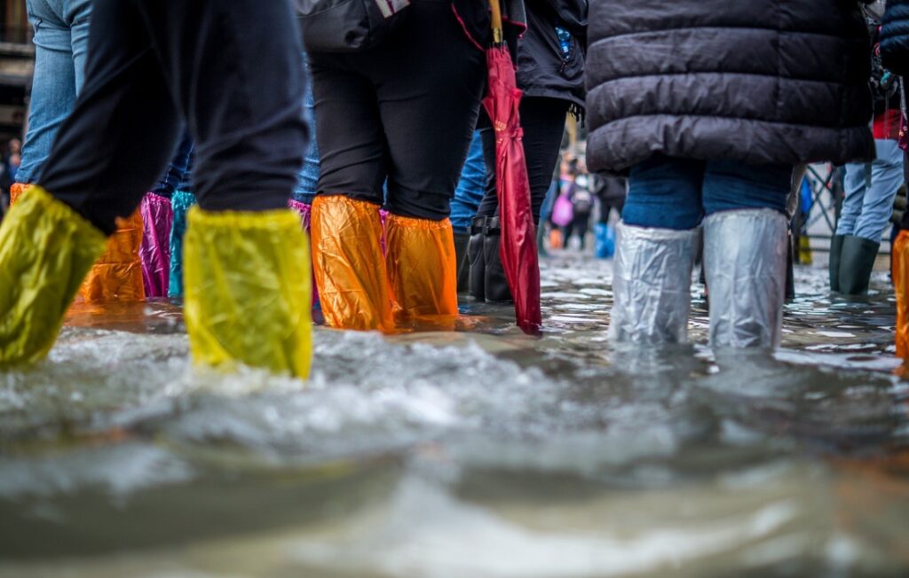 la gente se para en las aguas de la inundación