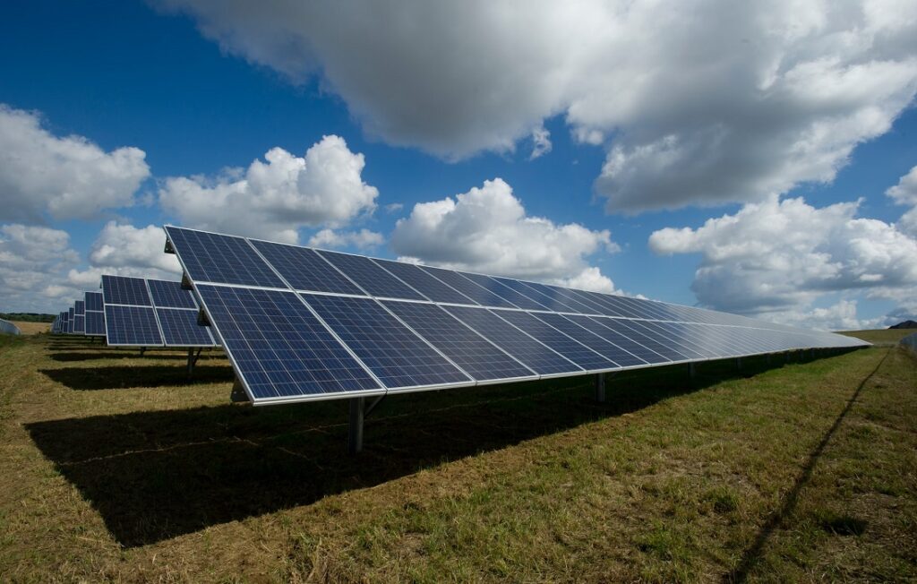 sun shining on solar panels in field