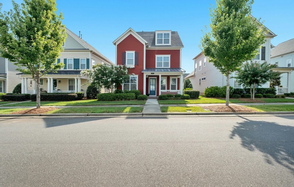 red house on street in suburbs